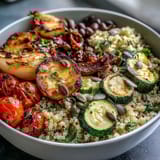 Close-up of a hearty Veggie and Quinoa Power Bowl drizzled with zesty lemon vinaigrette, served in a rustic ceramic bowl.