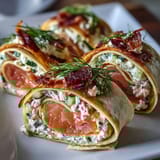 Delicate smoked salmon pinwheels wrapped in soft tortillas with cool cucumber and zesty cream cheese, ideal for entertaining.  