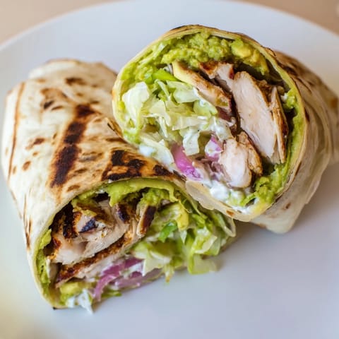 Grilled smoky chipotle chicken slices nestled in a warm tortilla with crisp romaine, avocado, and red onion.  