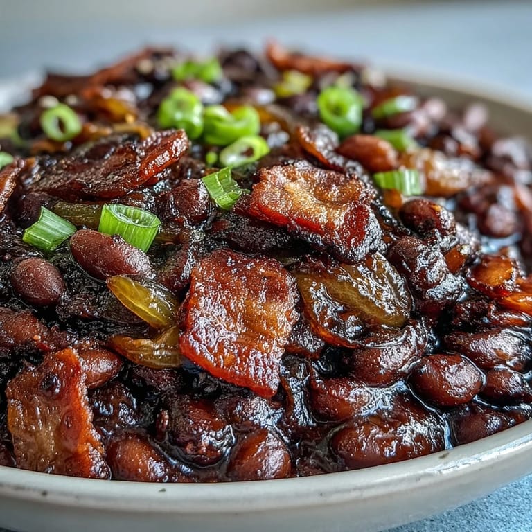 Hearty molasses baked beans with crisp bacon highlights this soulful American side.